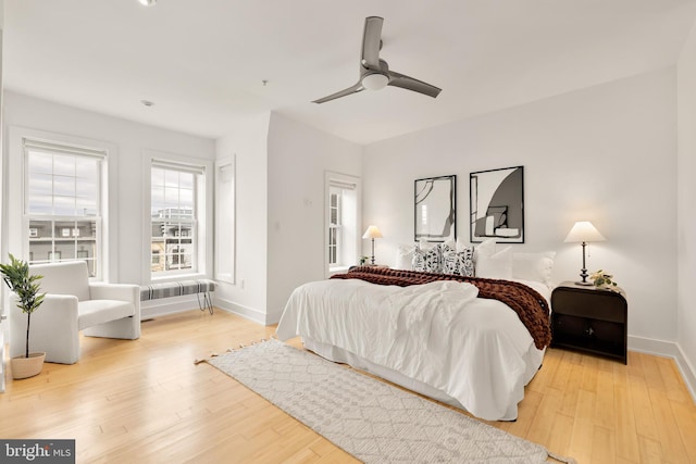 bedroom featuring ceiling fan, light wood-type flooring, and baseboards