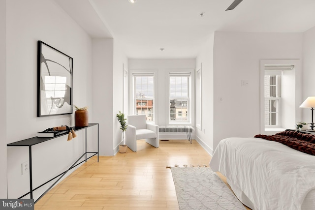 bedroom featuring ceiling fan, light wood finished floors, and baseboards