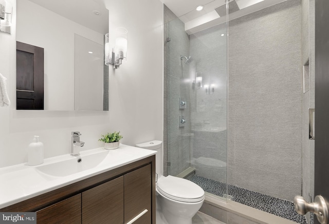 bathroom with a stall shower, vanity, and toilet