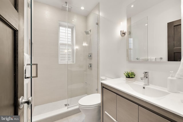 bathroom with a stall shower, vanity, toilet, and recessed lighting