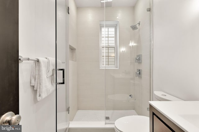 bathroom featuring toilet, a shower stall, visible vents, and vanity