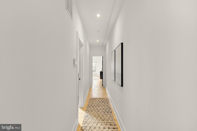 hall with baseboards, light wood-type flooring, visible vents, and recessed lighting