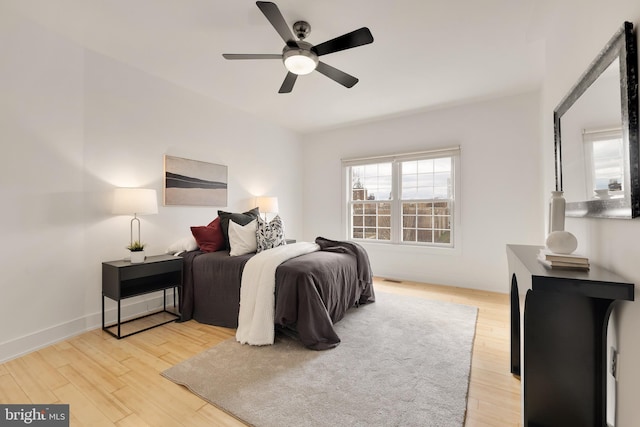 bedroom featuring light wood-style floors, ceiling fan, and baseboards