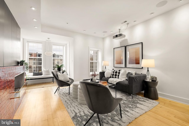 sitting room with light wood-style floors, visible vents, baseboards, and recessed lighting