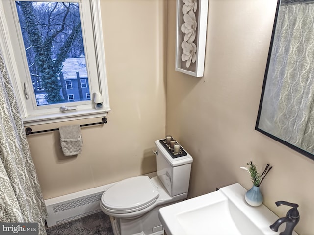 bathroom featuring toilet, a baseboard radiator, and a sink