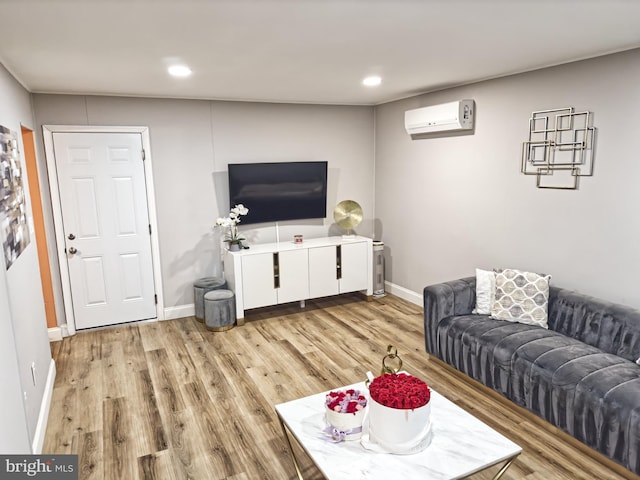 living room with recessed lighting, a wall unit AC, light wood-style flooring, and baseboards