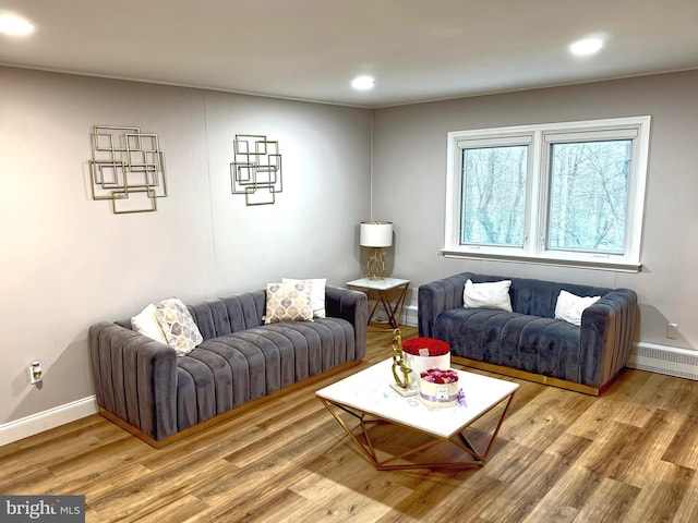 living area featuring light wood finished floors, baseboards, a baseboard heating unit, and recessed lighting