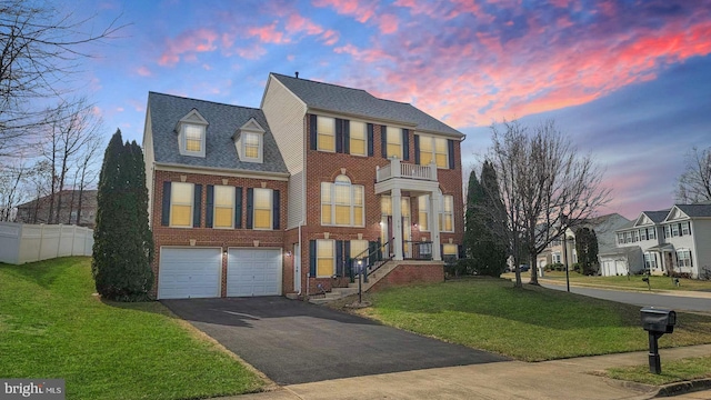 view of front of house featuring aphalt driveway, a balcony, brick siding, fence, and a front lawn