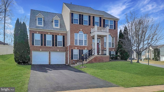 view of front of property featuring a front yard, aphalt driveway, and brick siding