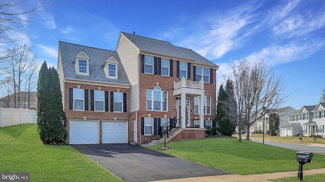 view of front of property with driveway, brick siding, a front lawn, and fence