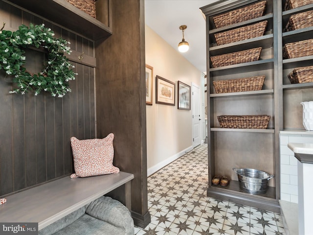 mudroom with baseboards, built in shelves, and tile patterned floors