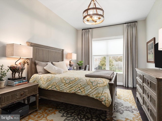 bedroom featuring a notable chandelier and wood finished floors