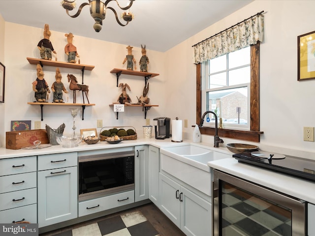 kitchen with wine cooler, stainless steel microwave, light countertops, open shelves, and a sink