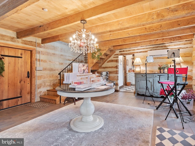 dining room with a wall unit AC, wooden ceiling, wood finished floors, stairs, and beamed ceiling