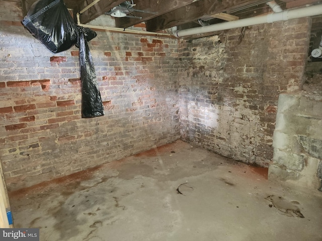 unfinished basement featuring brick wall