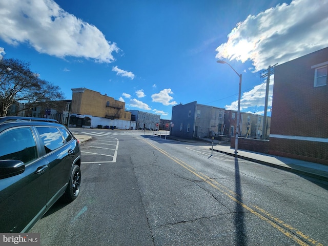 view of street featuring curbs, street lighting, and sidewalks