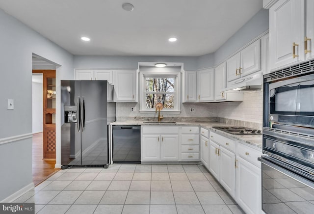 kitchen featuring light tile patterned floors, white cabinets, a sink, under cabinet range hood, and black appliances