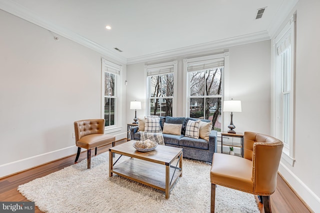 living area featuring ornamental molding, recessed lighting, wood finished floors, and baseboards