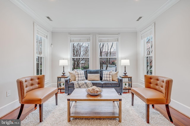 living room with ornamental molding, visible vents, and wood finished floors