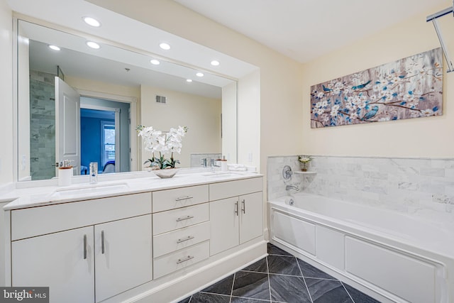 full bath with visible vents, a sink, a garden tub, and double vanity