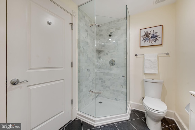 full bathroom featuring toilet, a shower stall, baseboards, and tile patterned flooring