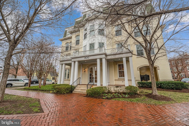 view of front of property featuring brick siding and a balcony