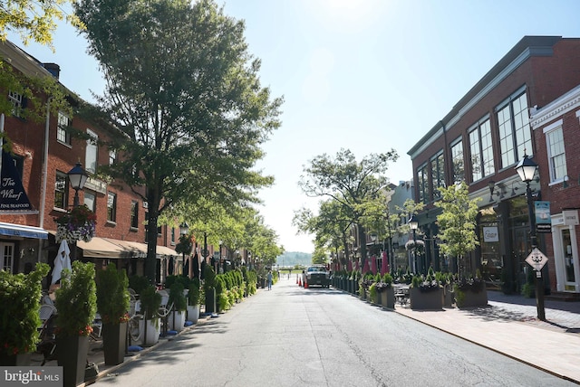 view of street featuring street lights, sidewalks, and a residential view