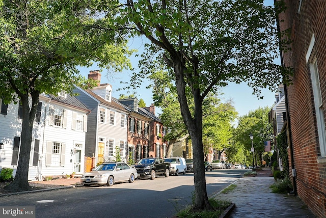 view of street with sidewalks, street lights, a residential view, and curbs