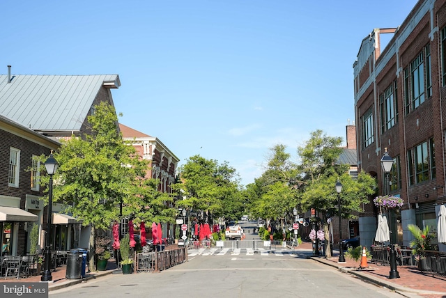 view of street featuring sidewalks, traffic signs, curbs, and street lights