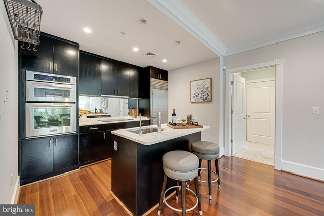 kitchen featuring appliances with stainless steel finishes, dark cabinetry, a sink, and visible vents