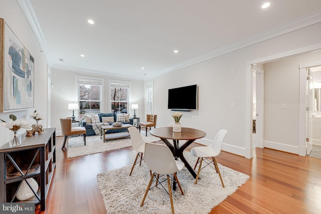 dining room featuring ornamental molding, light wood-type flooring, baseboards, and recessed lighting