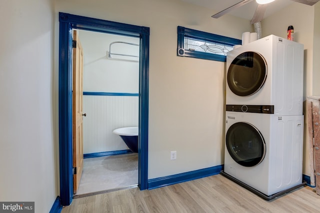 laundry room with laundry area, baseboards, a ceiling fan, stacked washer and clothes dryer, and wood finished floors