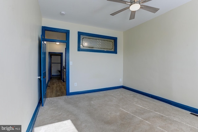 empty room with carpet floors, ceiling fan, and baseboards