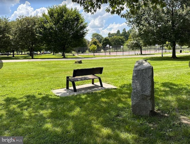 view of community with fence and a lawn