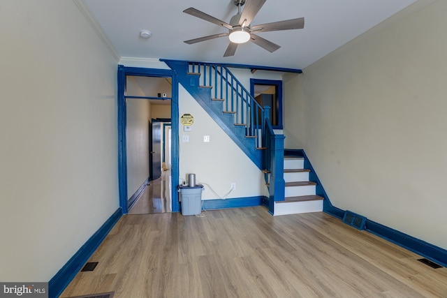 staircase featuring baseboards, wood finished floors, visible vents, and crown molding