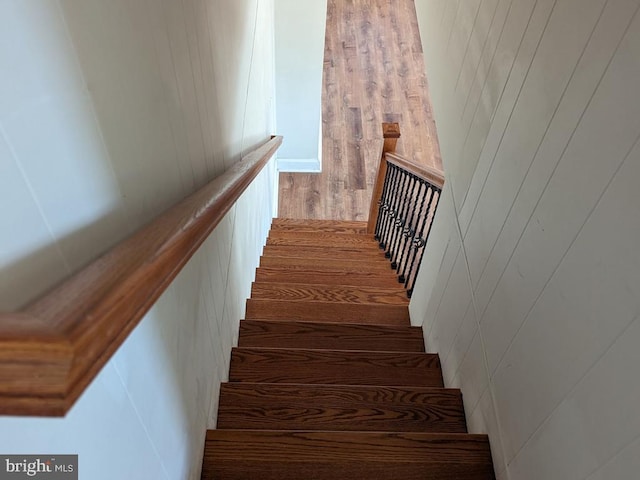 stairs featuring wood finished floors