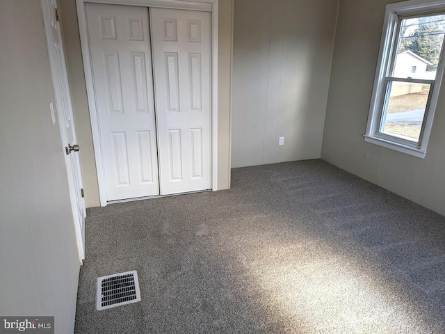 unfurnished bedroom with carpet floors and visible vents