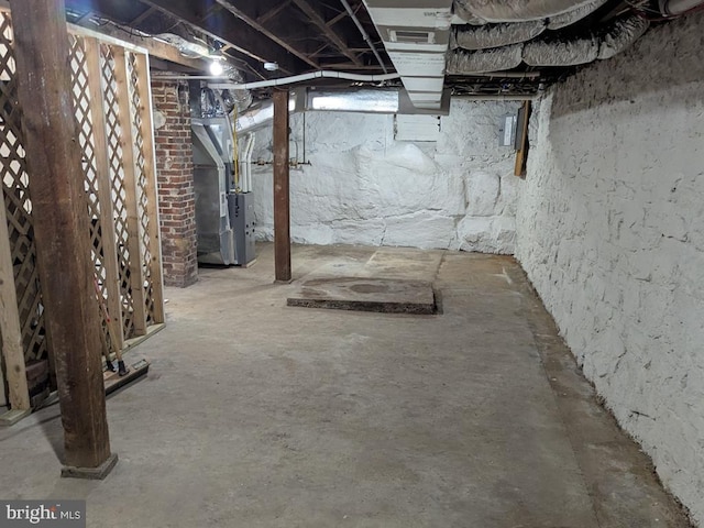 unfinished basement featuring visible vents and heating unit