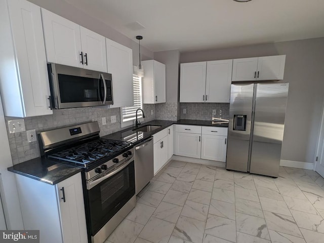 kitchen featuring marble finish floor, stainless steel appliances, a sink, and white cabinets