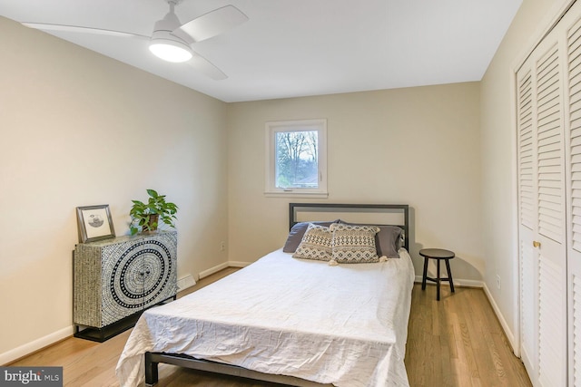 bedroom featuring ceiling fan, a closet, baseboards, and wood finished floors