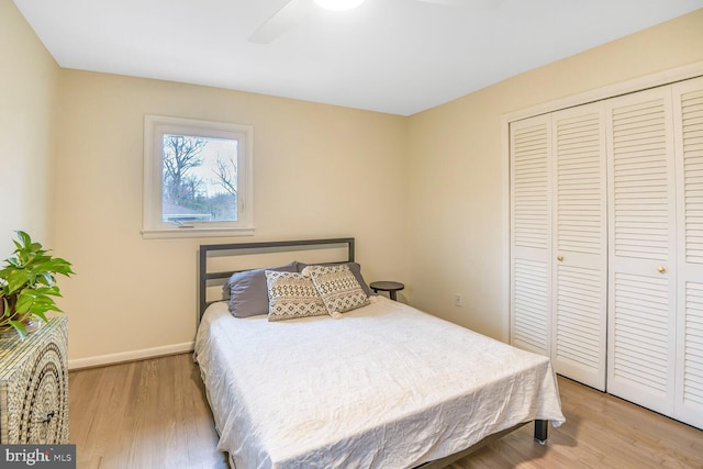 bedroom featuring ceiling fan, a closet, baseboards, and wood finished floors