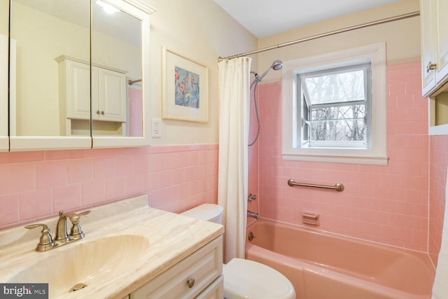 full bath featuring toilet, vanity, tile walls, and shower / tub combo with curtain