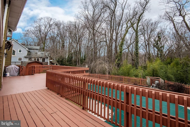 wooden terrace with fence private yard, a patio area, and a covered pool