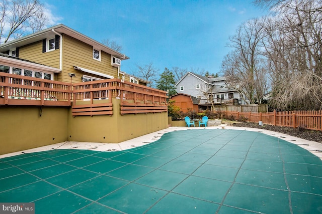 view of swimming pool featuring a patio area, fence, a wooden deck, and a fenced in pool