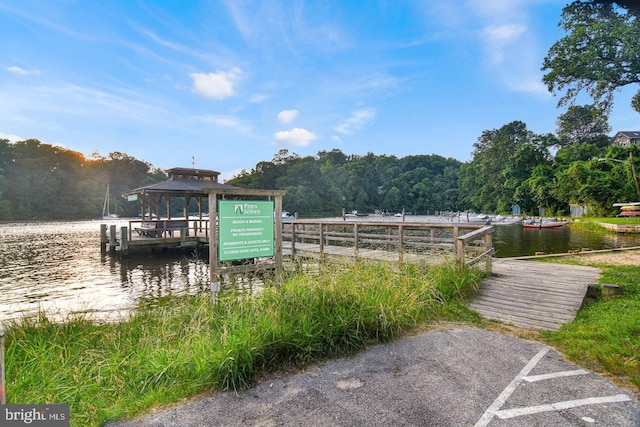 view of dock with a water view and a wooded view