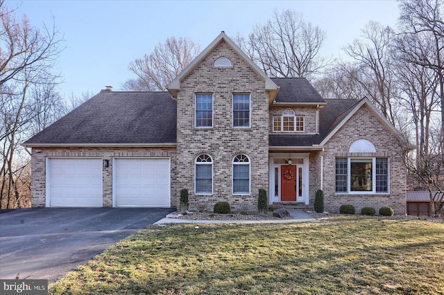 traditional-style house with a garage, brick siding, a shingled roof, driveway, and a front lawn