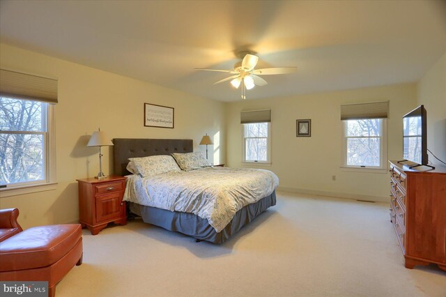 bedroom featuring baseboards, a ceiling fan, and light colored carpet