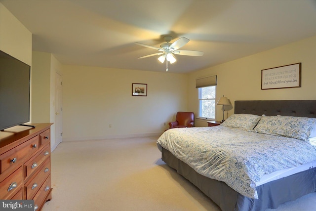 bedroom with light carpet, ceiling fan, and baseboards