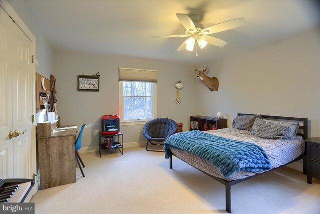 carpeted bedroom with a ceiling fan and baseboards