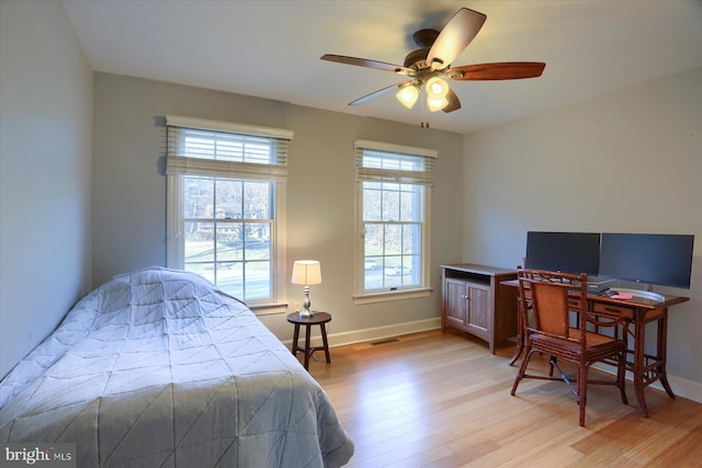 bedroom with light wood-style floors, visible vents, ceiling fan, and baseboards